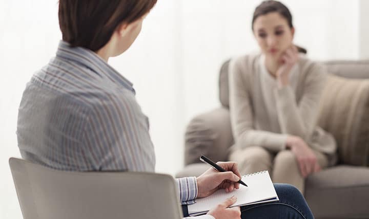 Therapist meets with patient in cozy office.