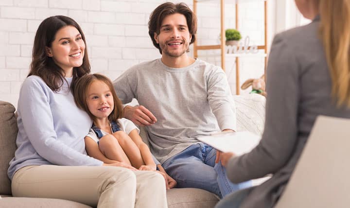 Therapist meets with family in cozy office.