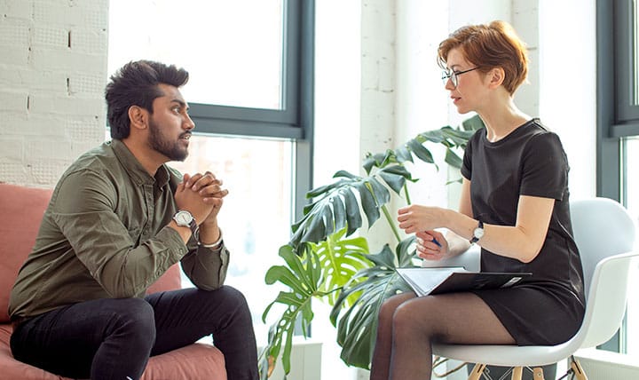 Therapist meets with patient in cozy office.